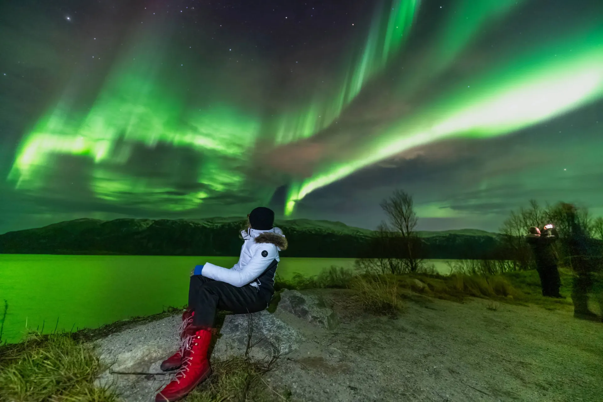 aurora northern lights group beside camp fire