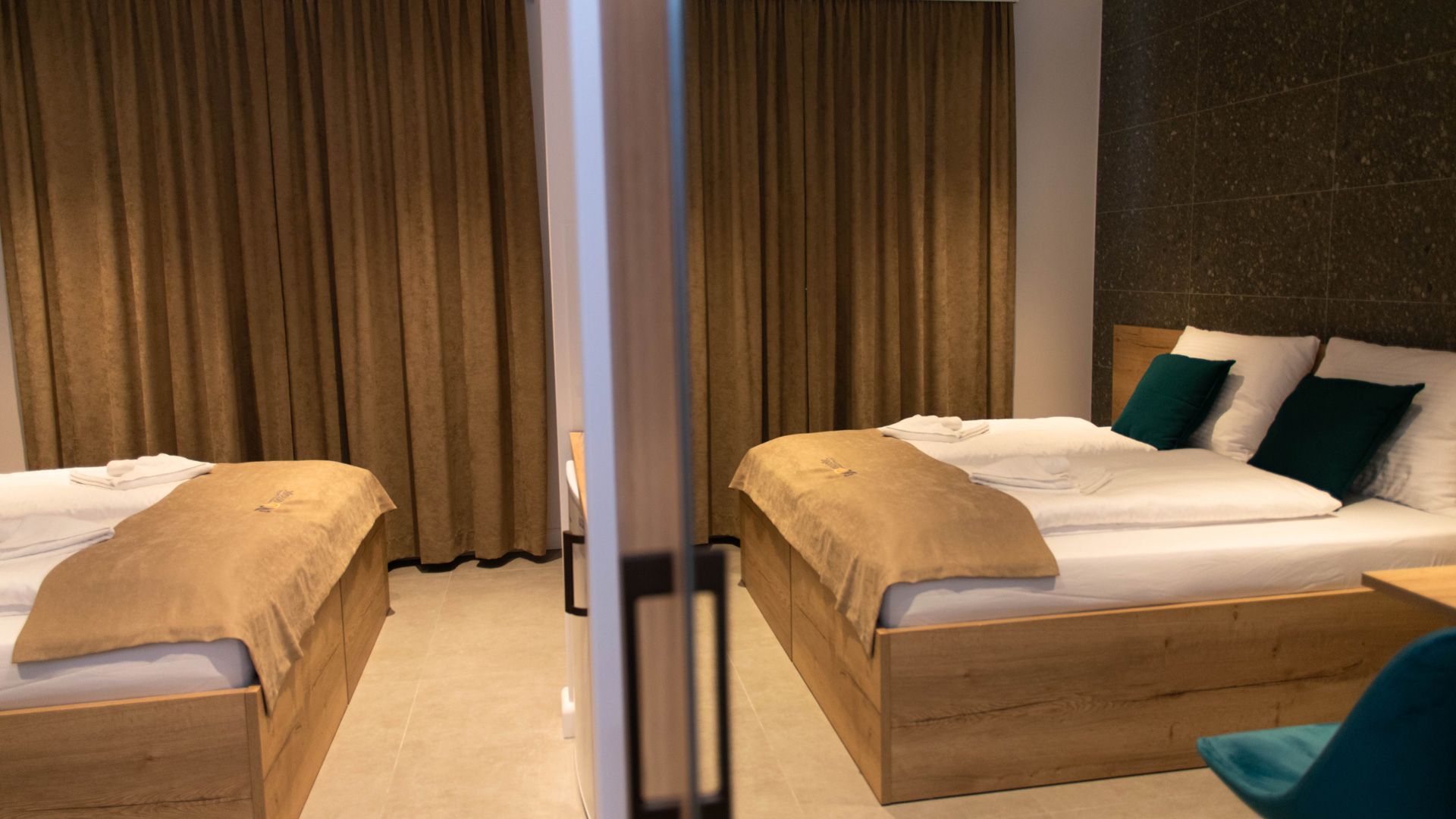 Una camera albergo con due letti e una sedia.