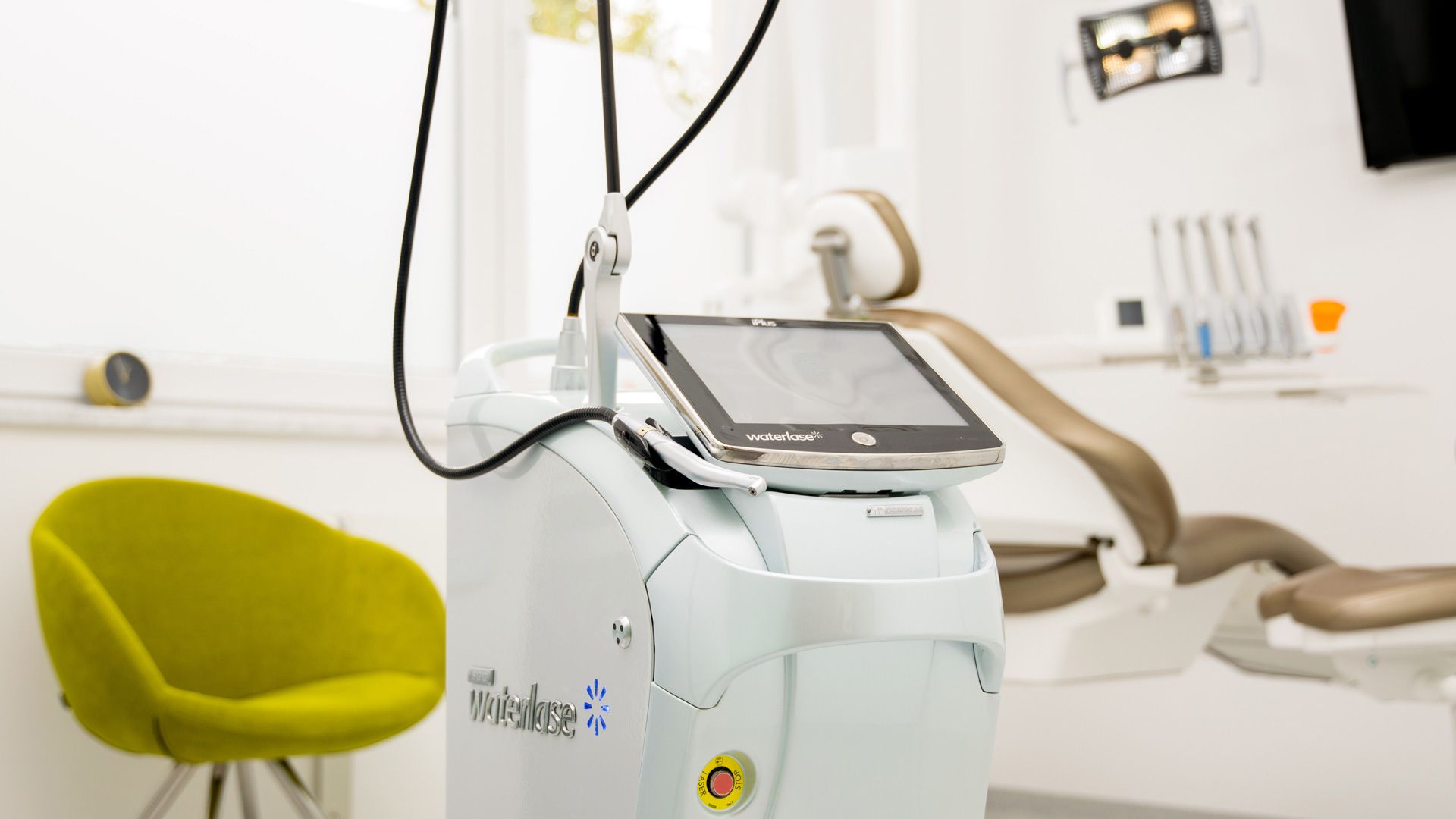 Uno studio dentistico con una poltrona odontoiatrica e una macchina.