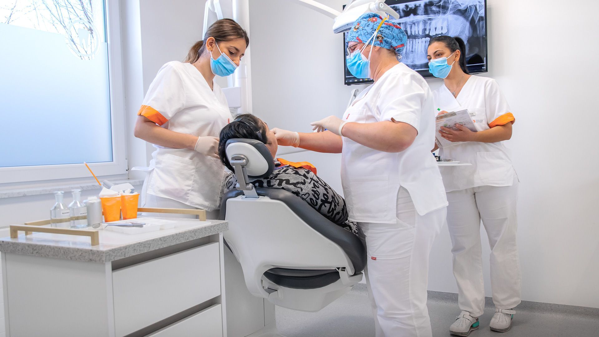 Un gruppo di dentisti sta lavorando su un paziente in uno studio dentistico.