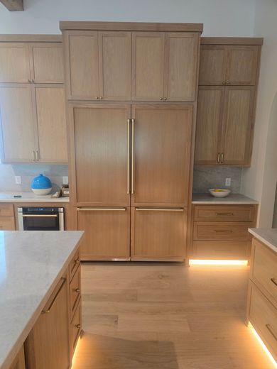Modern kitchen with oak cabinets, central pantry-style cupboards, and a long counter on each side.