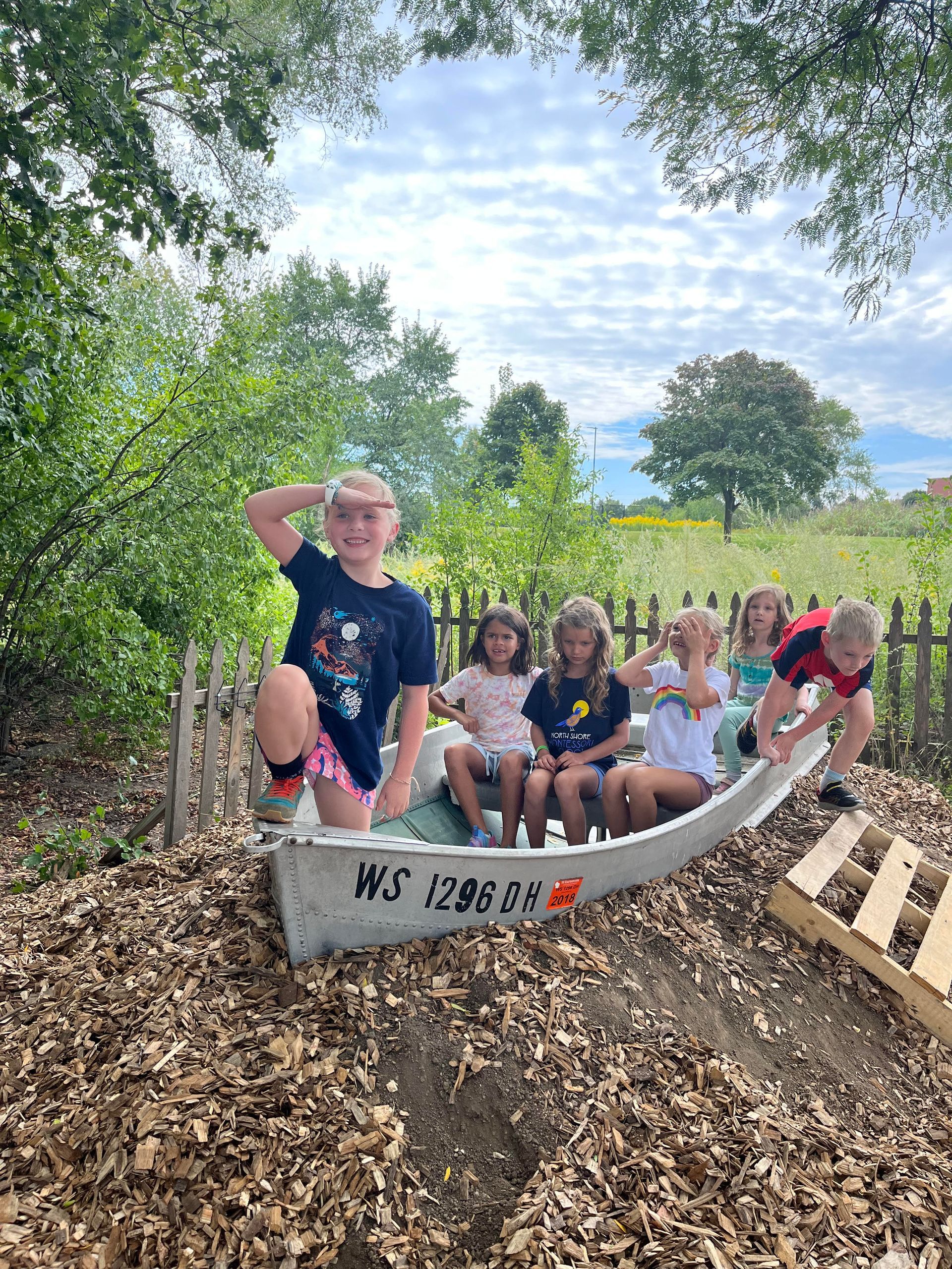 A group of children are sitting in a canoe.
