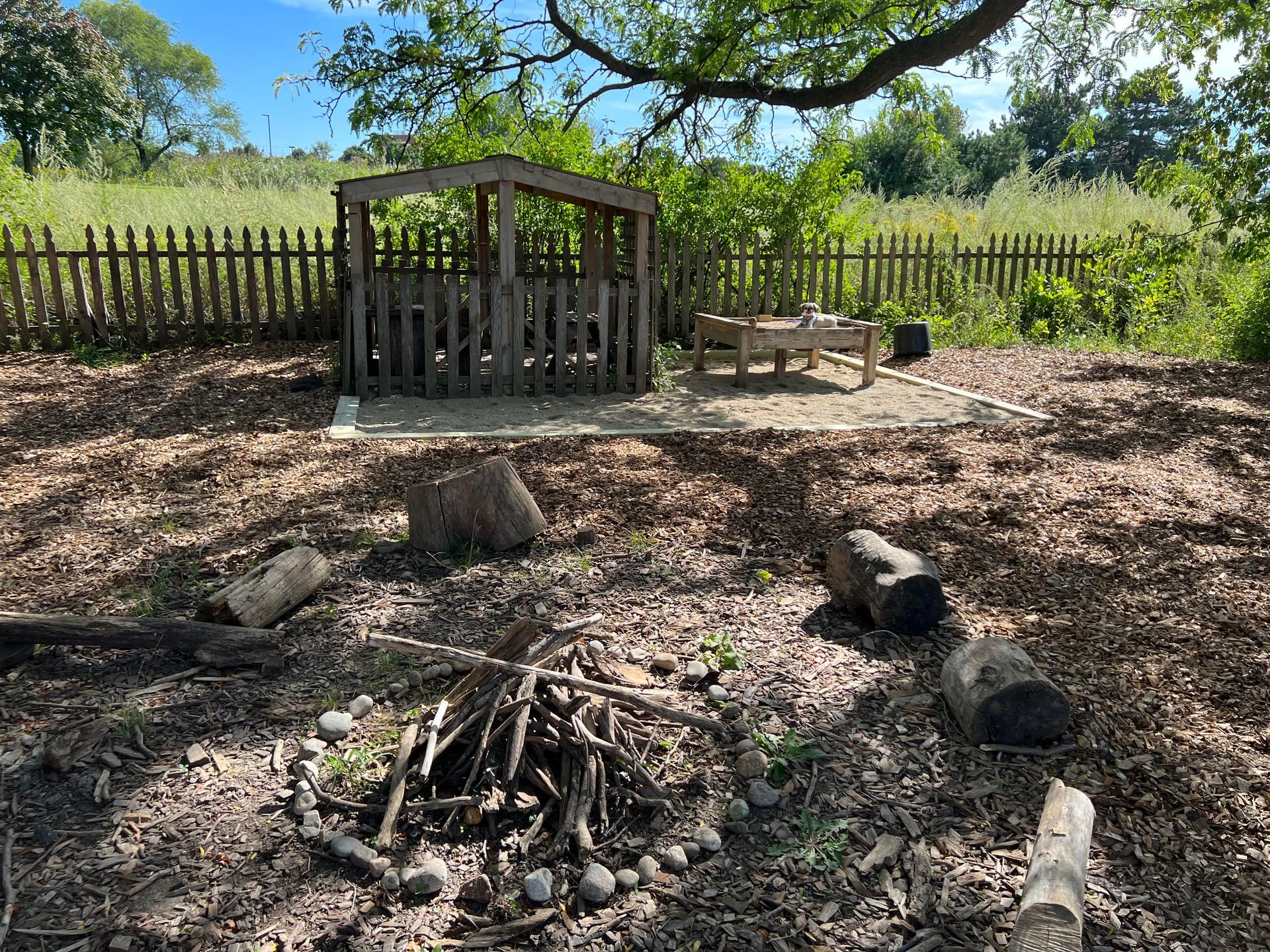 There is a fire pit in the middle of a field.