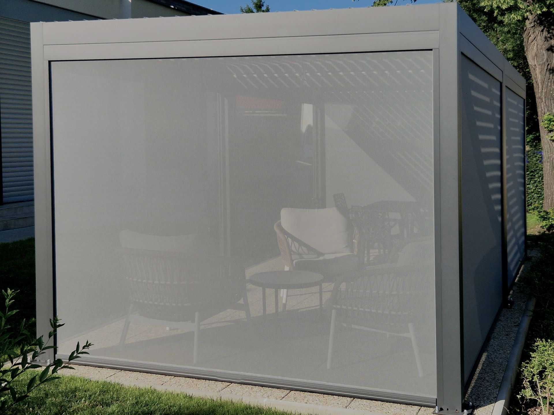 White mesh gazebo with outdoor seating in a backyard