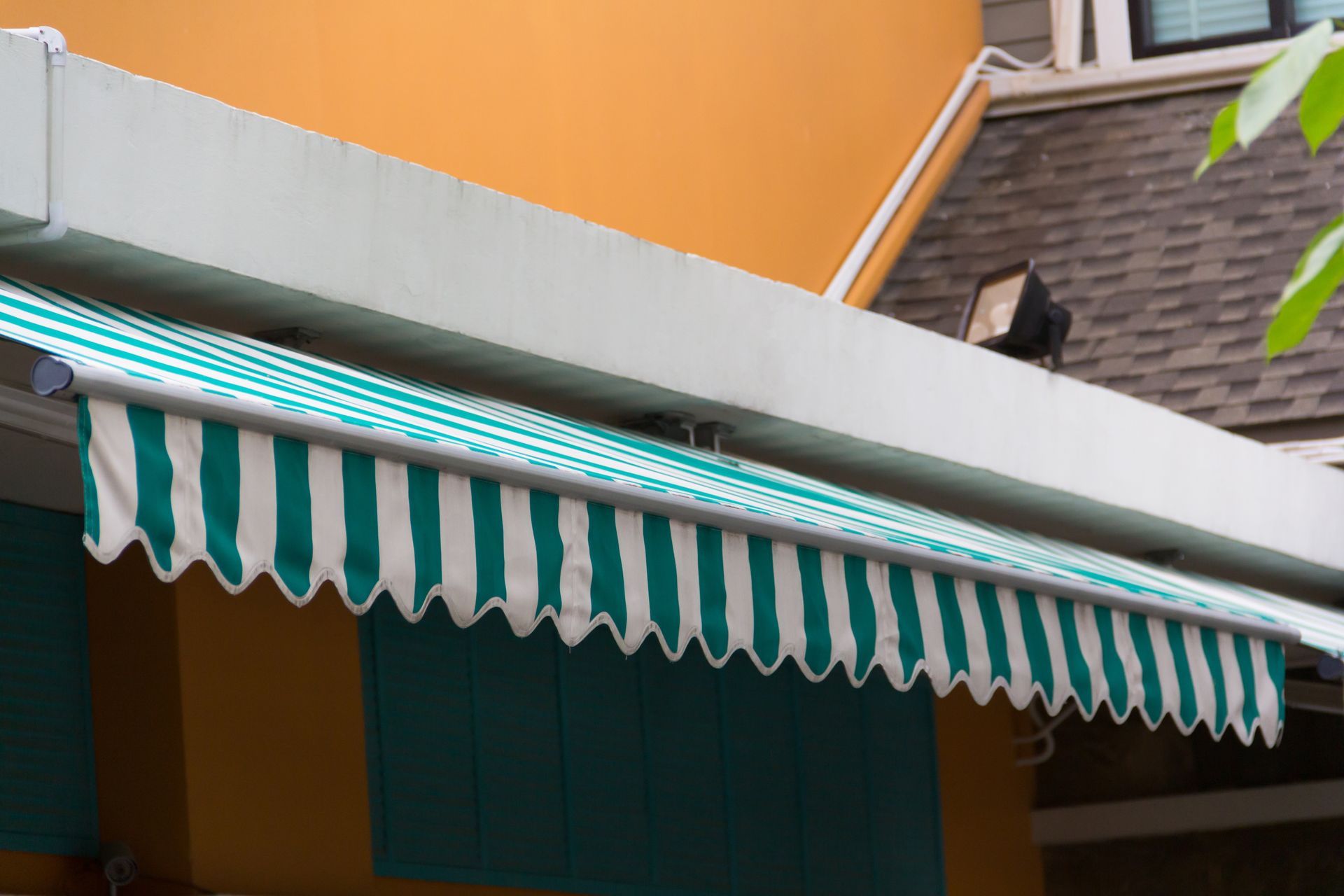 Green-and-white striped awning over a storefront against an orange building facade