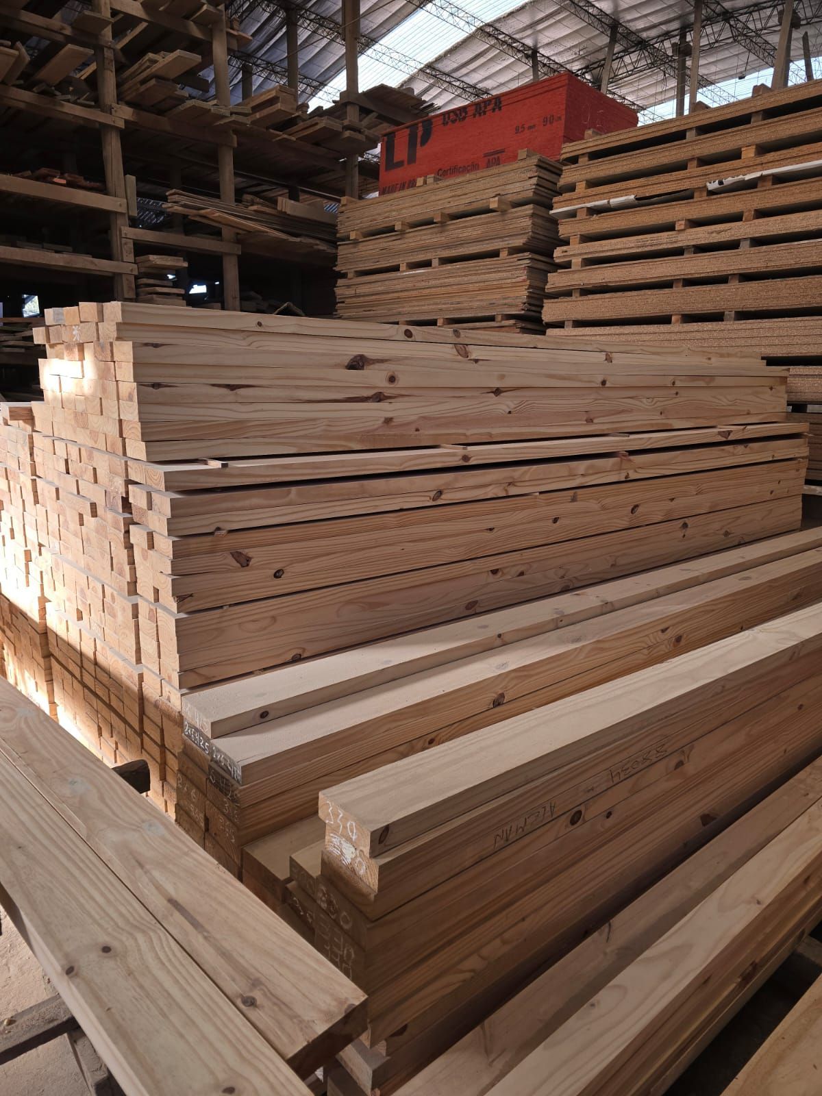 Un almacén lleno de muchas tablas de madera apiladas una encima de otra.