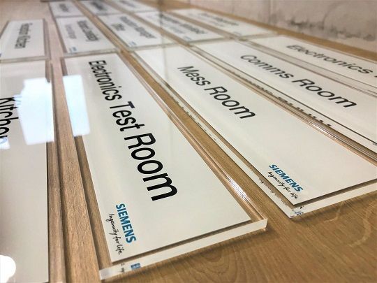 Lettering and branding on acrylic corporate office sign.