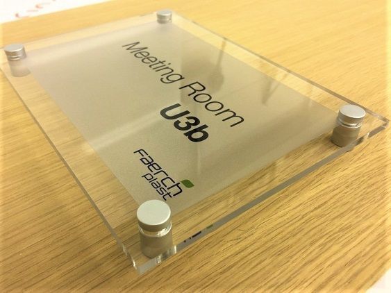Lettering and branding on acrylic corporate office sign.