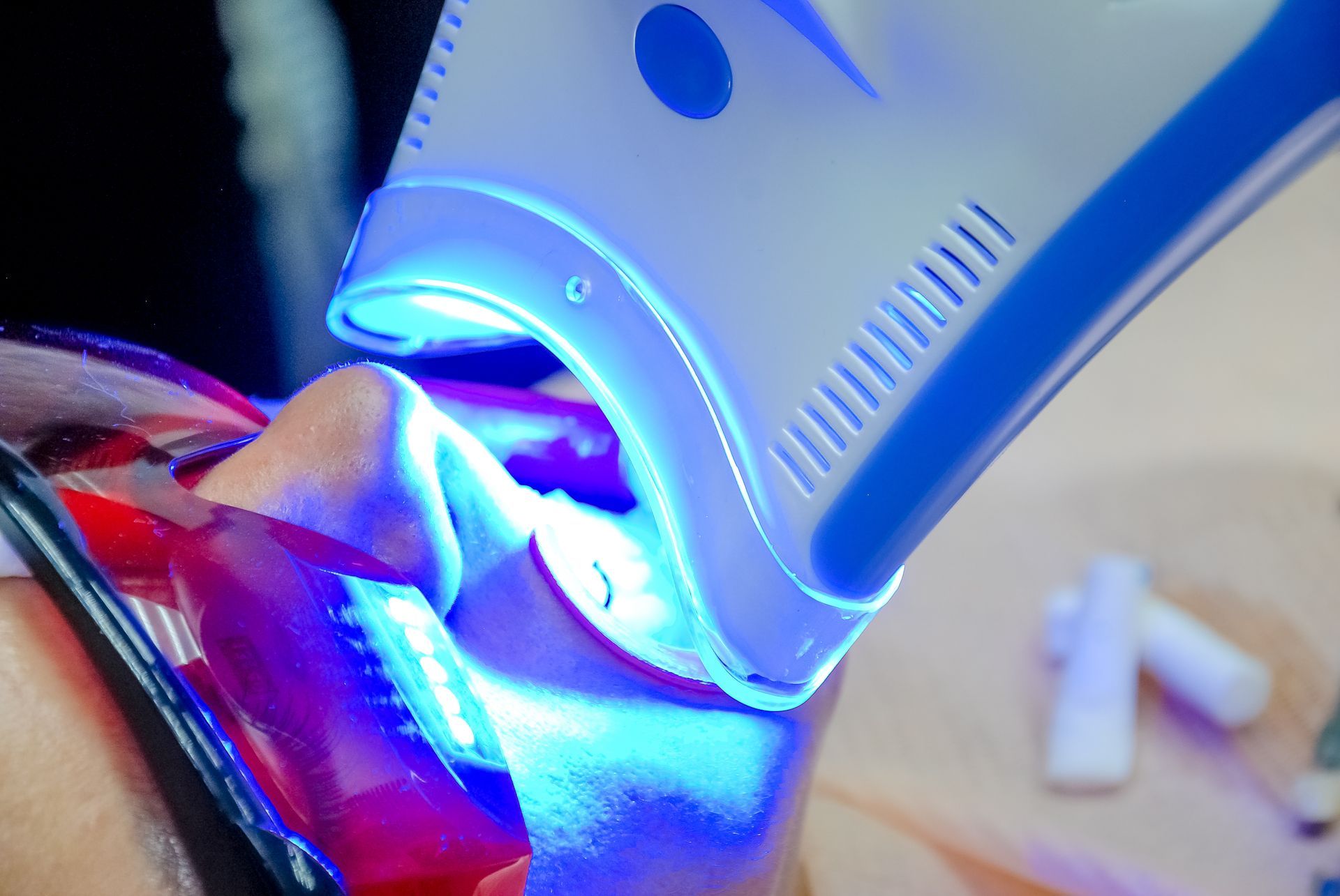 Blue light therapy device pressed against a person’s chin in a close-up facial treatment Blue light therapy device pressed against a person’s chin in a close-up facial treatment