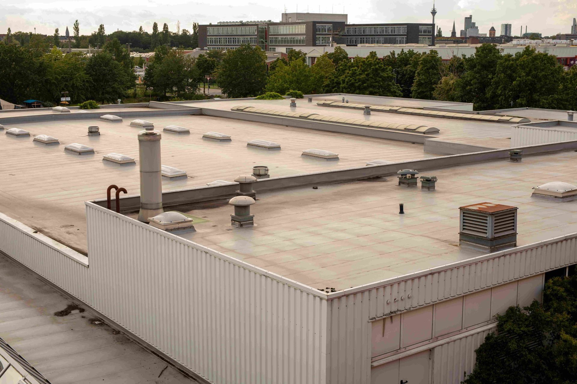 Blue corrugated metal roof with several vents and skylights