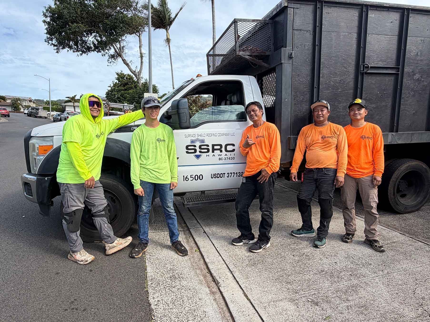 Five workers in hi-vis shirts stand by a SSRC utility truck at a roadside construction site