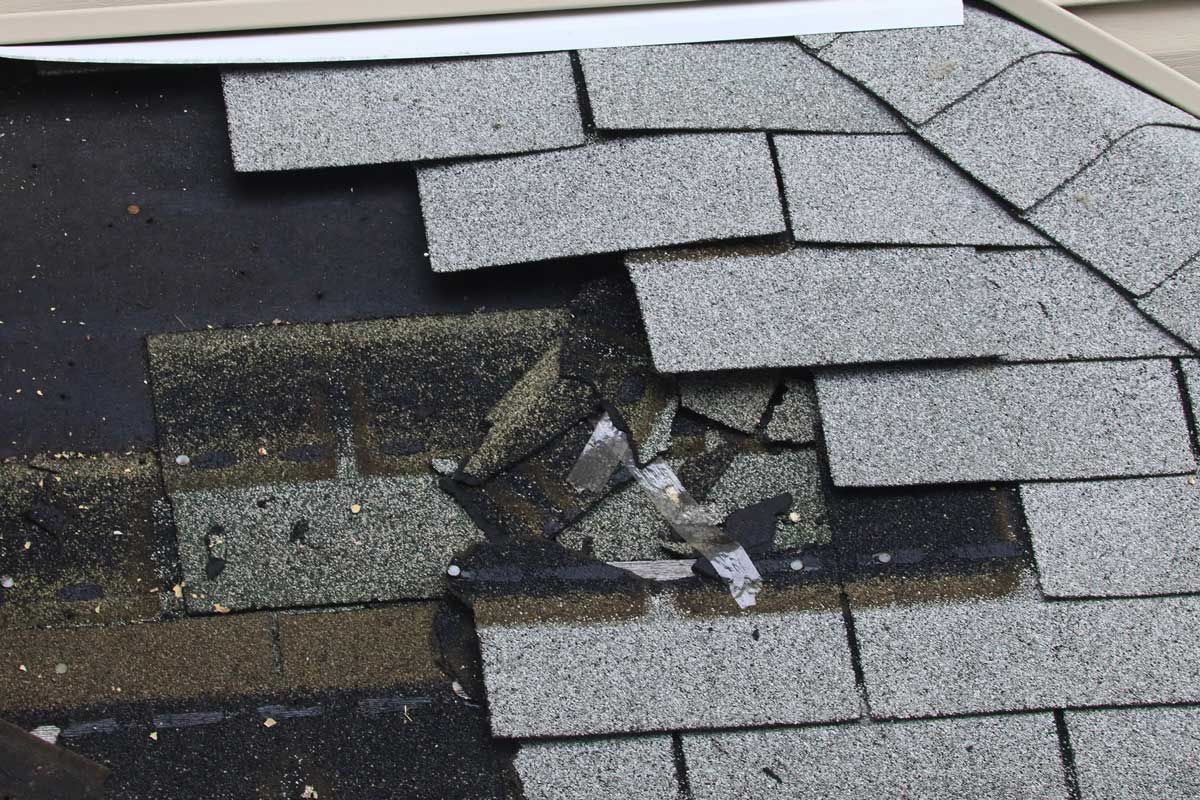 A damaged roof with missing shingles.