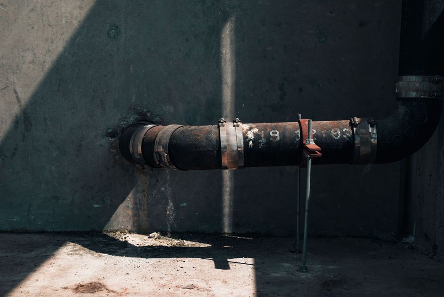 Hand opening the lid of a round green outdoor utility tank or well shaft