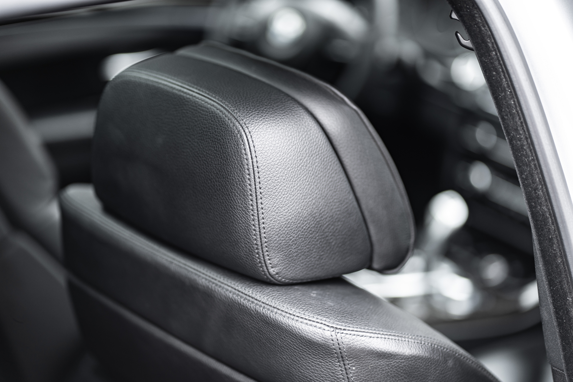 A person is cleaning the seats of a car with a brush.
