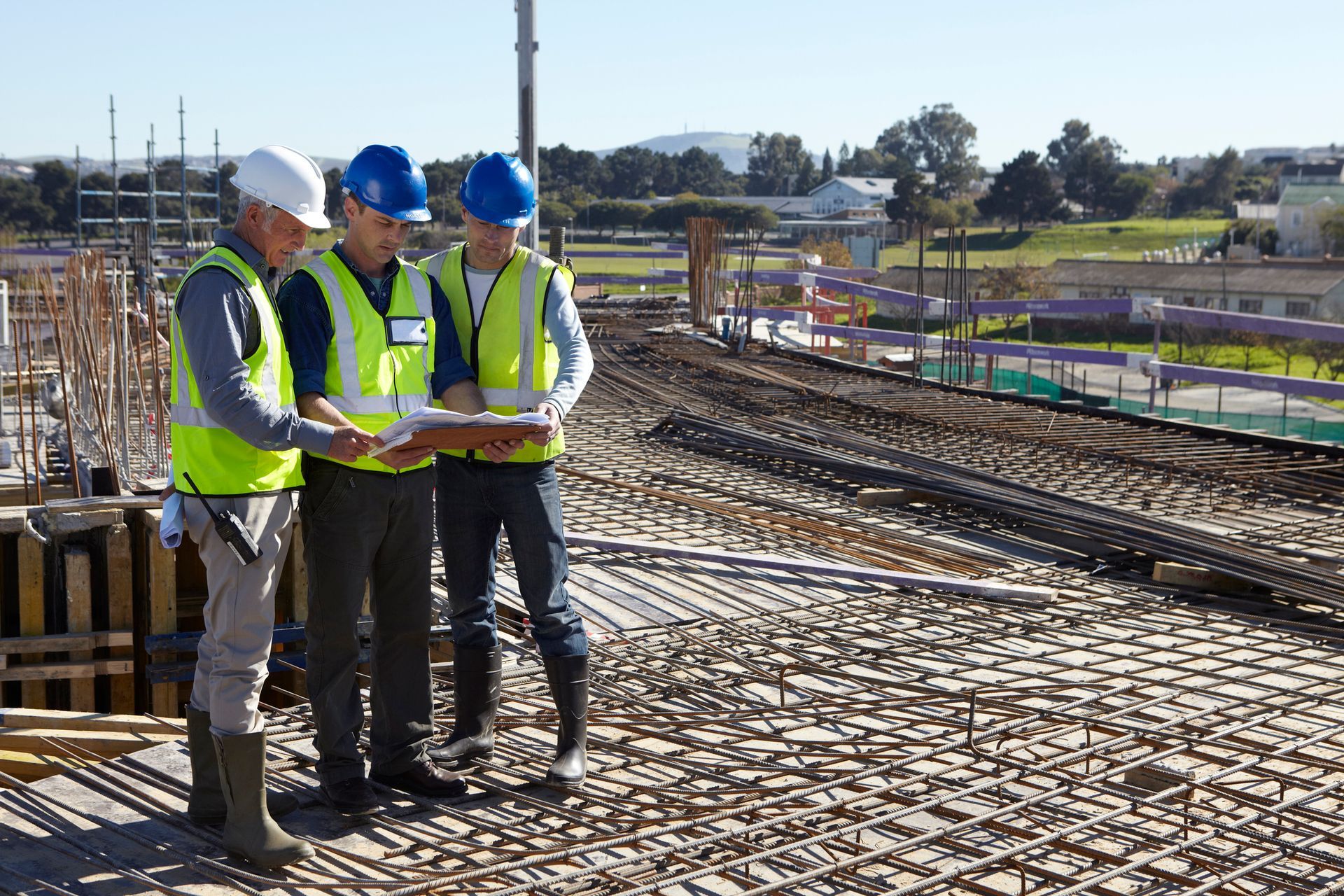 Un gruppo di operai edili sta osservando una planimetria in un cantiere.