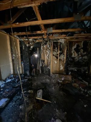 Restoration technician inspecting the gutted interior of a fire damaged residential property in Orlando FL