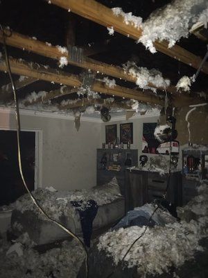Soot covered bedroom with fallen insulation after a house fire in Orlando FL