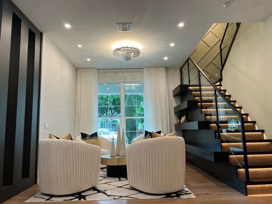 Rebuilt living room with floating staircase in a restored Orlando home after a fire