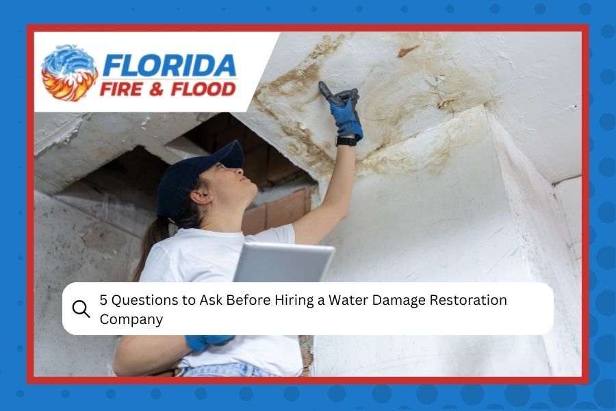 Florida Fire & Flood worker inspects water-damaged ceiling with tool in a flooded room