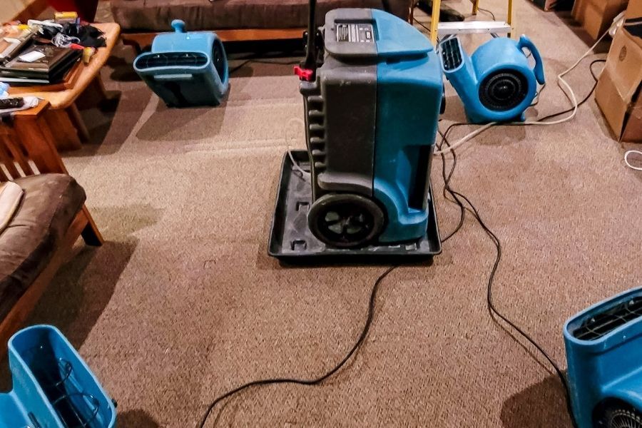 Commercial air movers and dehumidifiers drying a water-damaged room in a Central Florida home