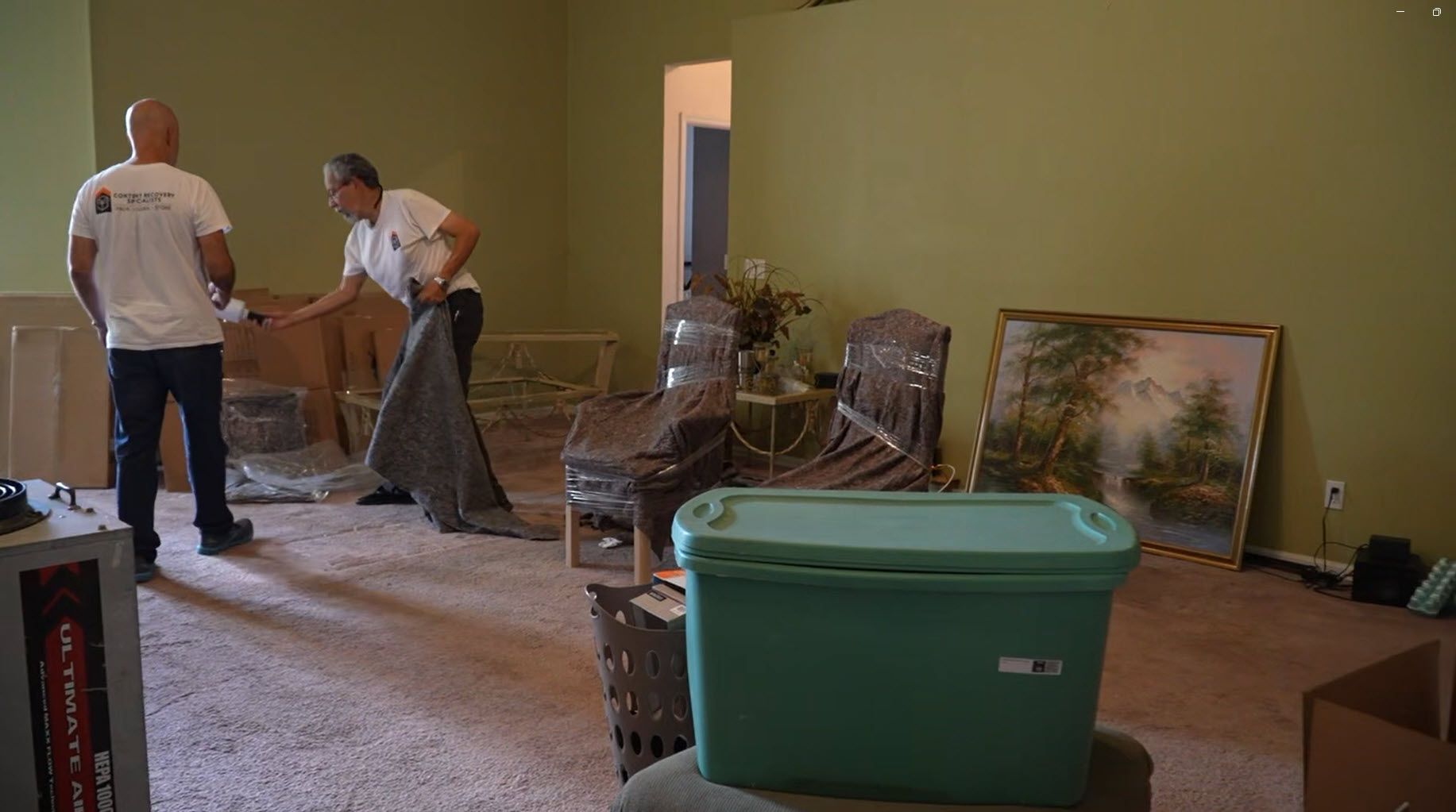 Restoration crew packing out contents from living room