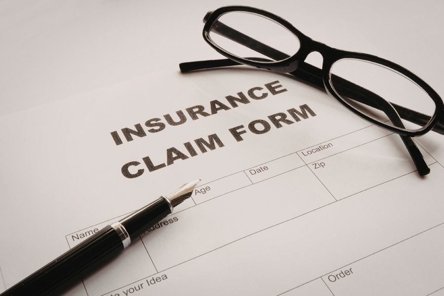 Insurance claim form with glasses and pen resting on a desk ready for storm damage documentation