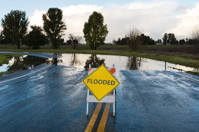 FFF's Team is serving a Flooded warning sign on a wet road in St. Petersburg, FL