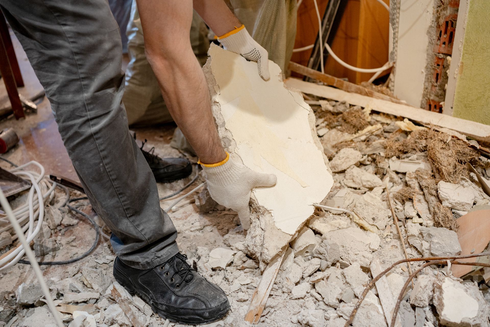 Workers removing rubble and broken drywall during building demolition
