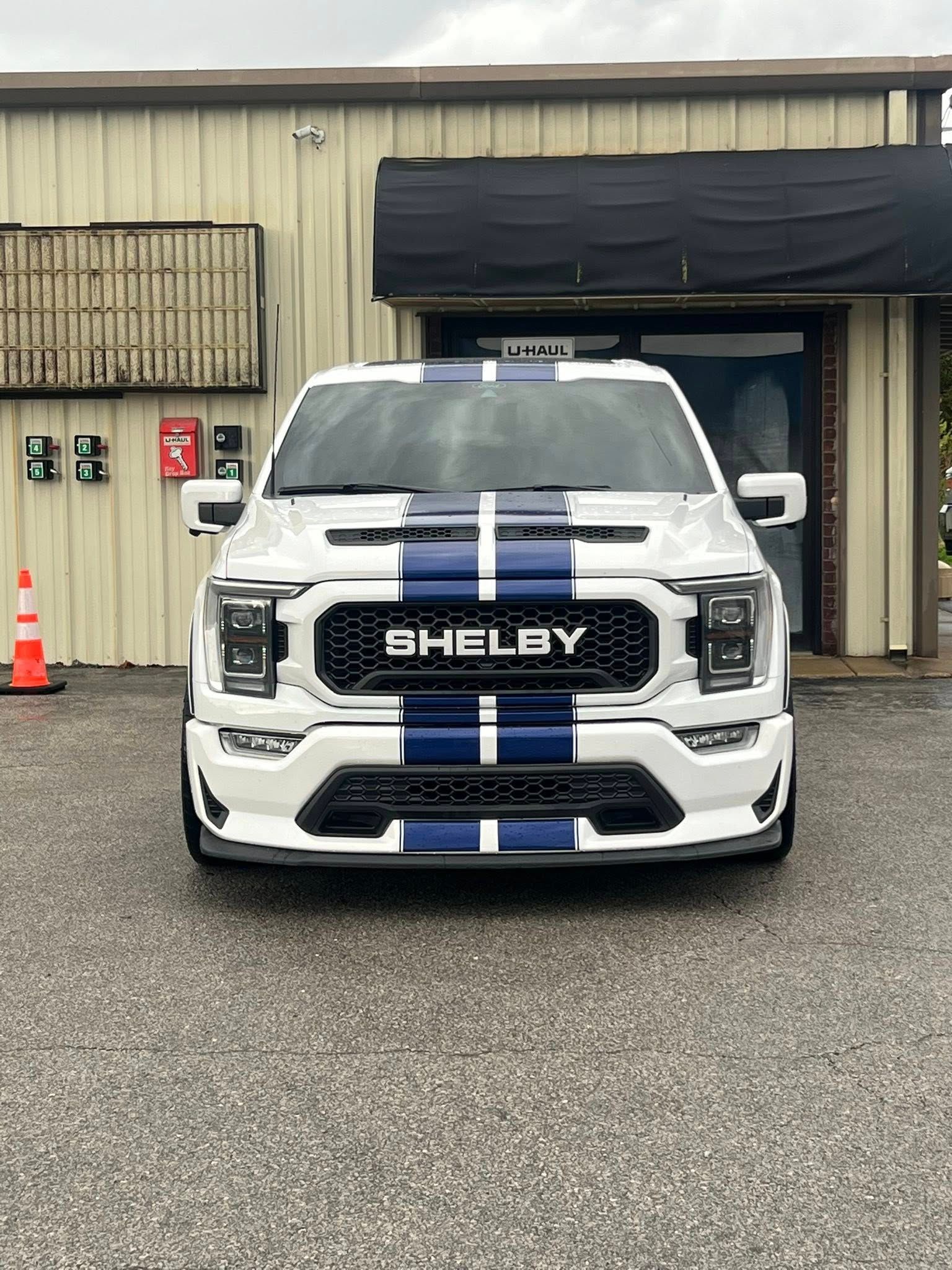 White Ford truck with blue racing stripes,