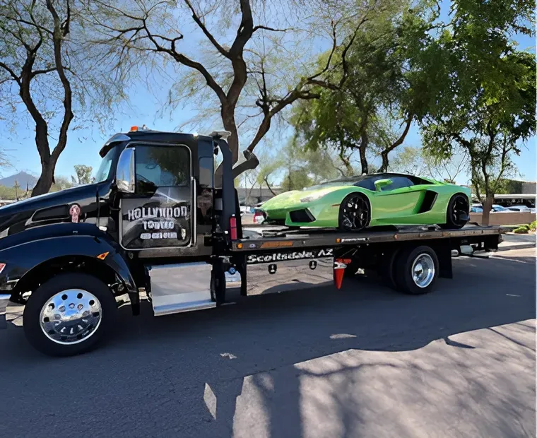 Tow truck hauling a bright green sports car on a flatbed in a sunny street scene