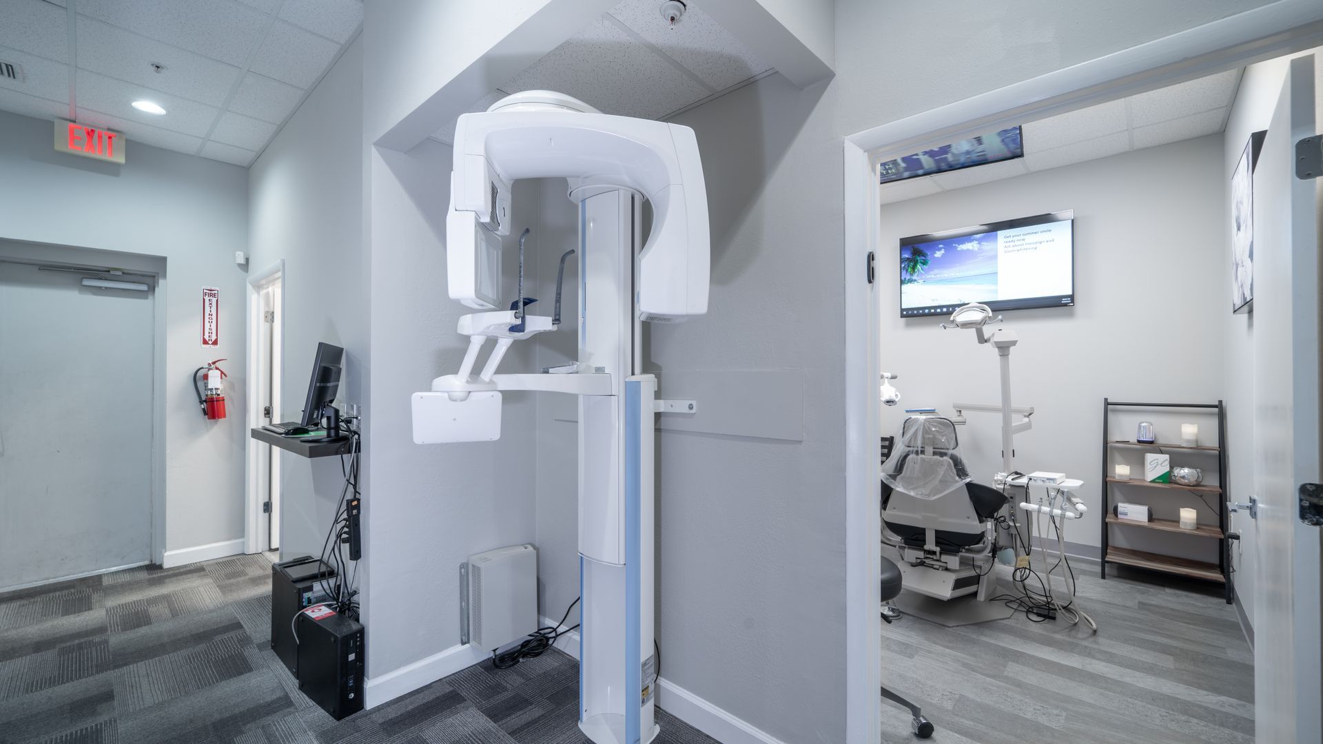 A dental office with a x-ray machine and a dental chair.