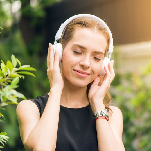 A woman wearing headphones is listening to music