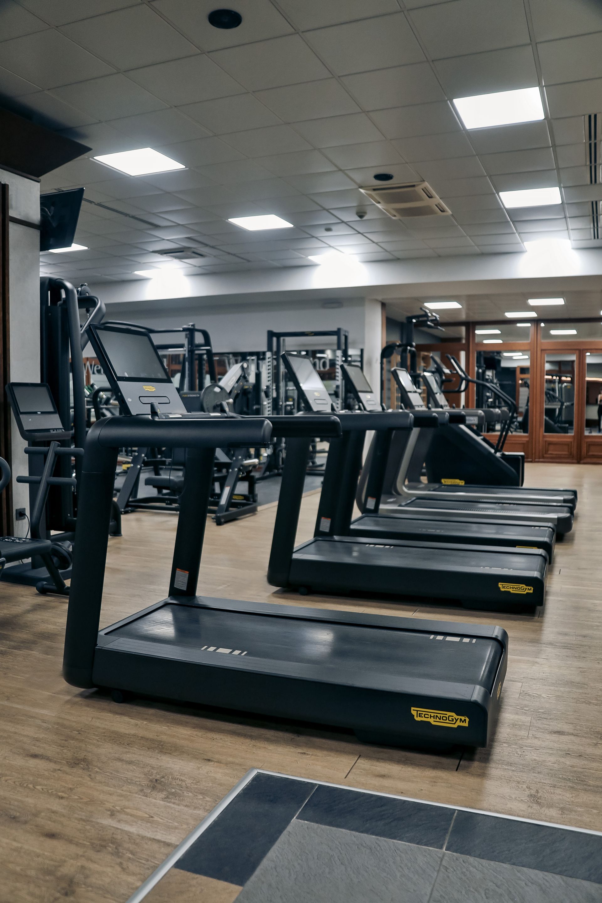 a row of treadmills are lined up in a gym .
