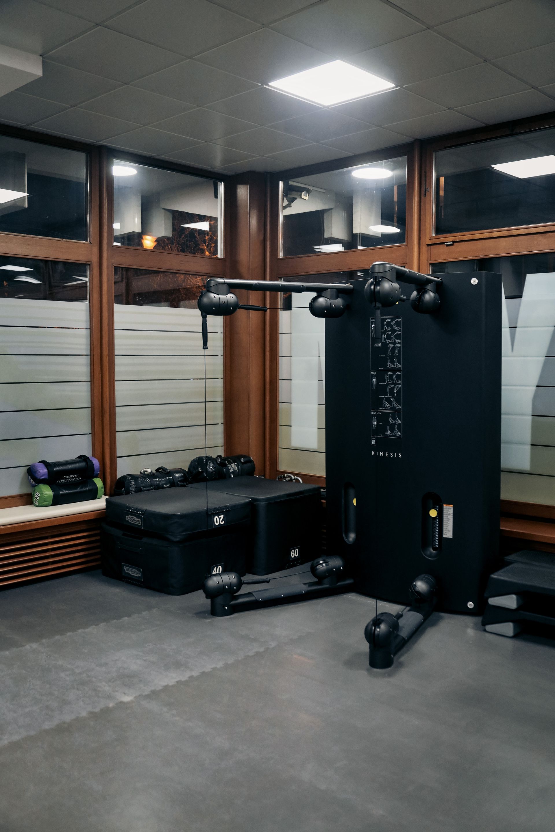 a gym with a lot of exercise equipment and a large window