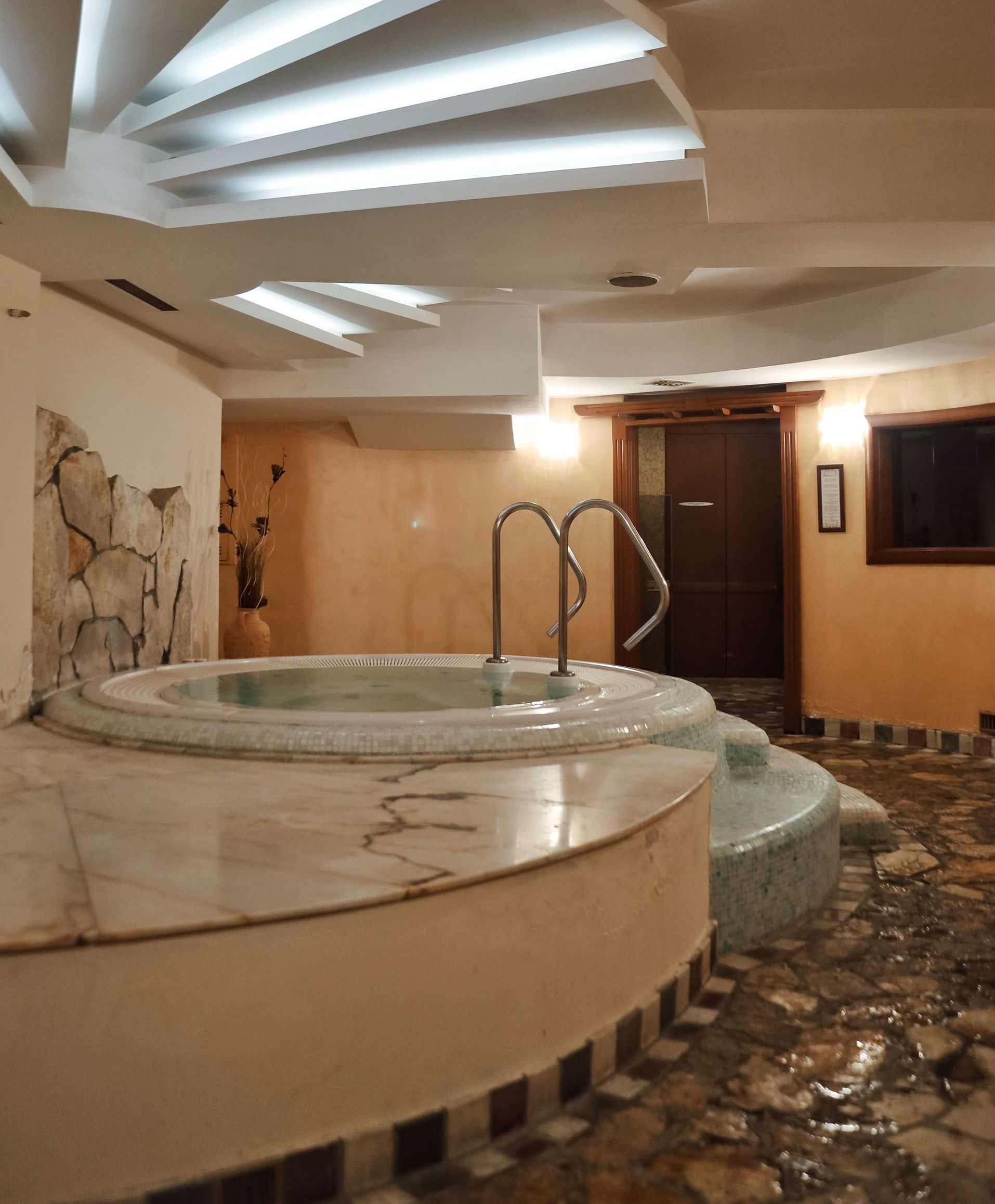 a jacuzzi in a room with stairs leading to it