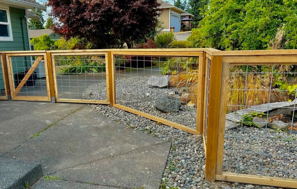 Wooden fence and gate beside a gravel path in a landscaped yard