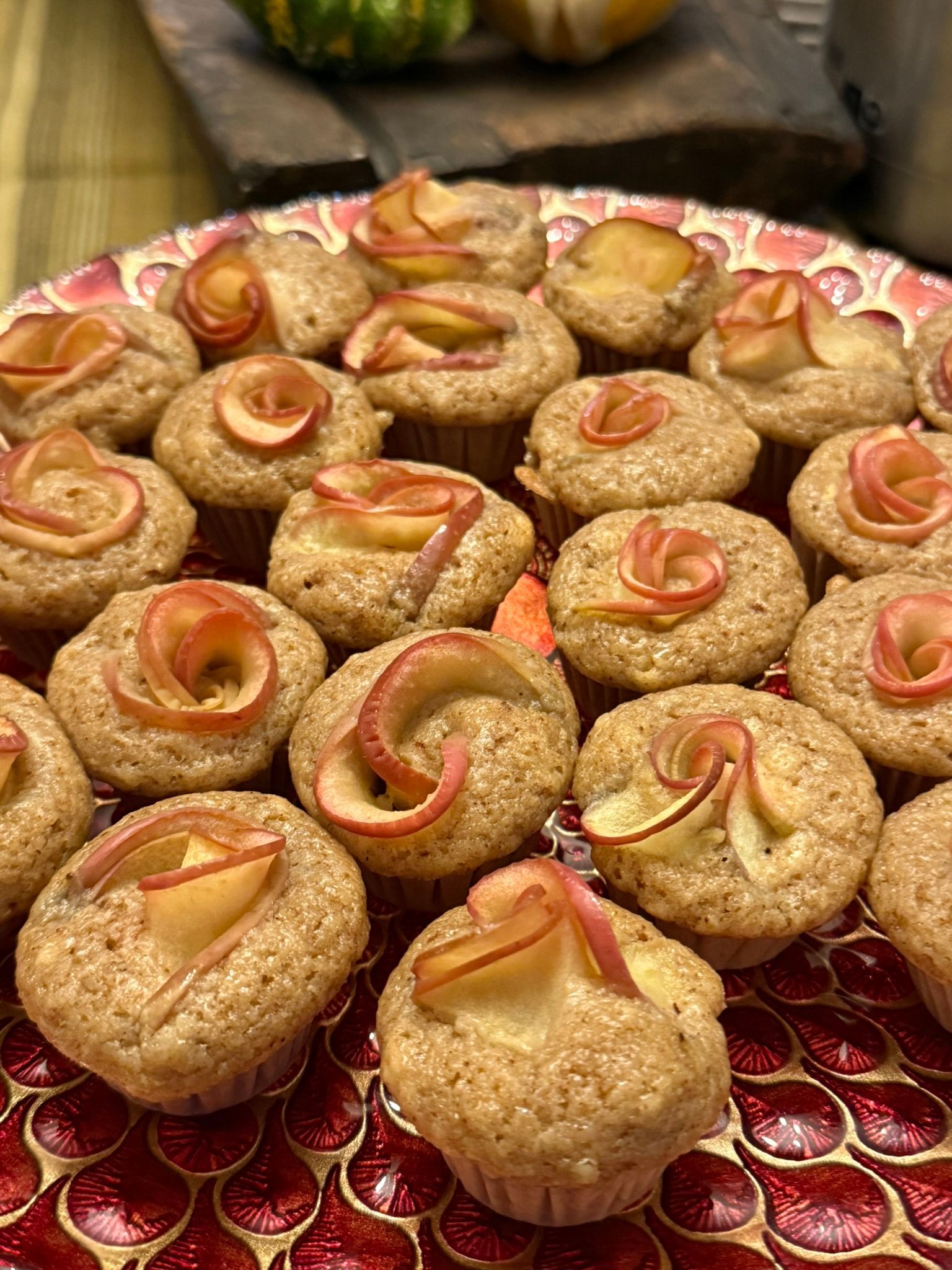 Tray of spiral apple pastries on a red patterned tablecloth