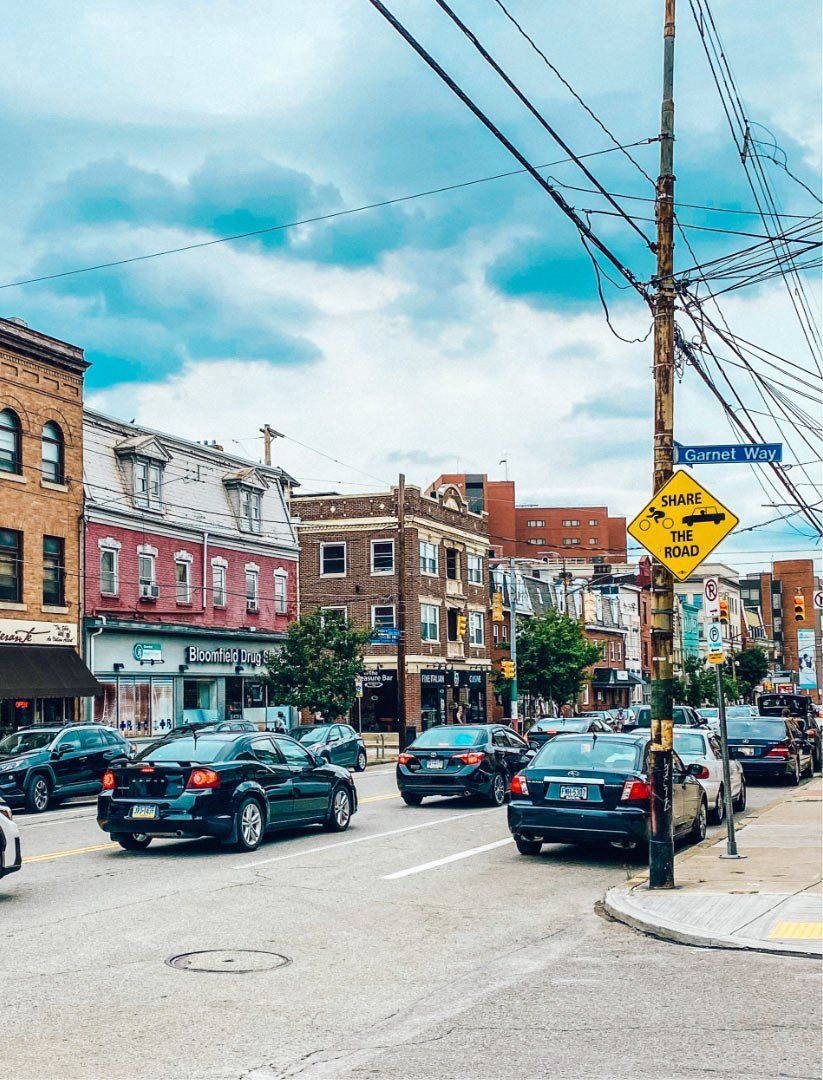 a busy city street with cars parked on the side of the road