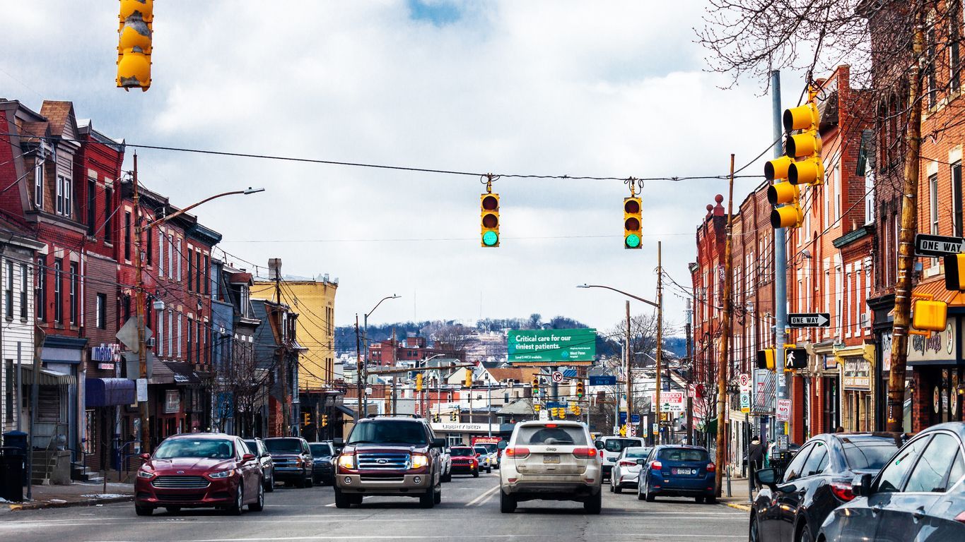 a busy city street with cars driving down it .