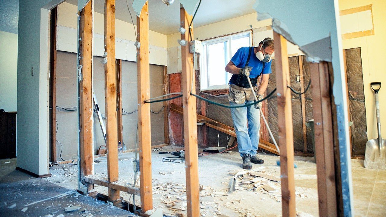 A man is standing in a room with a vacuum cleaner.