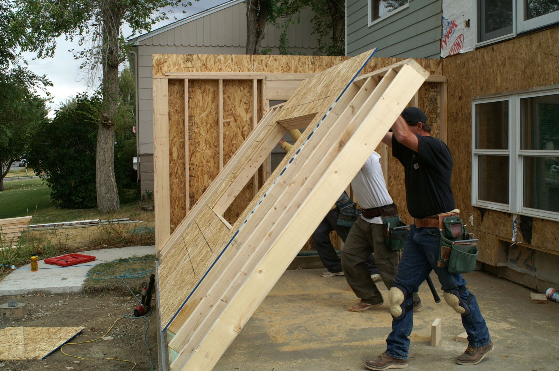 A group of men are carrying a large piece of wood.
