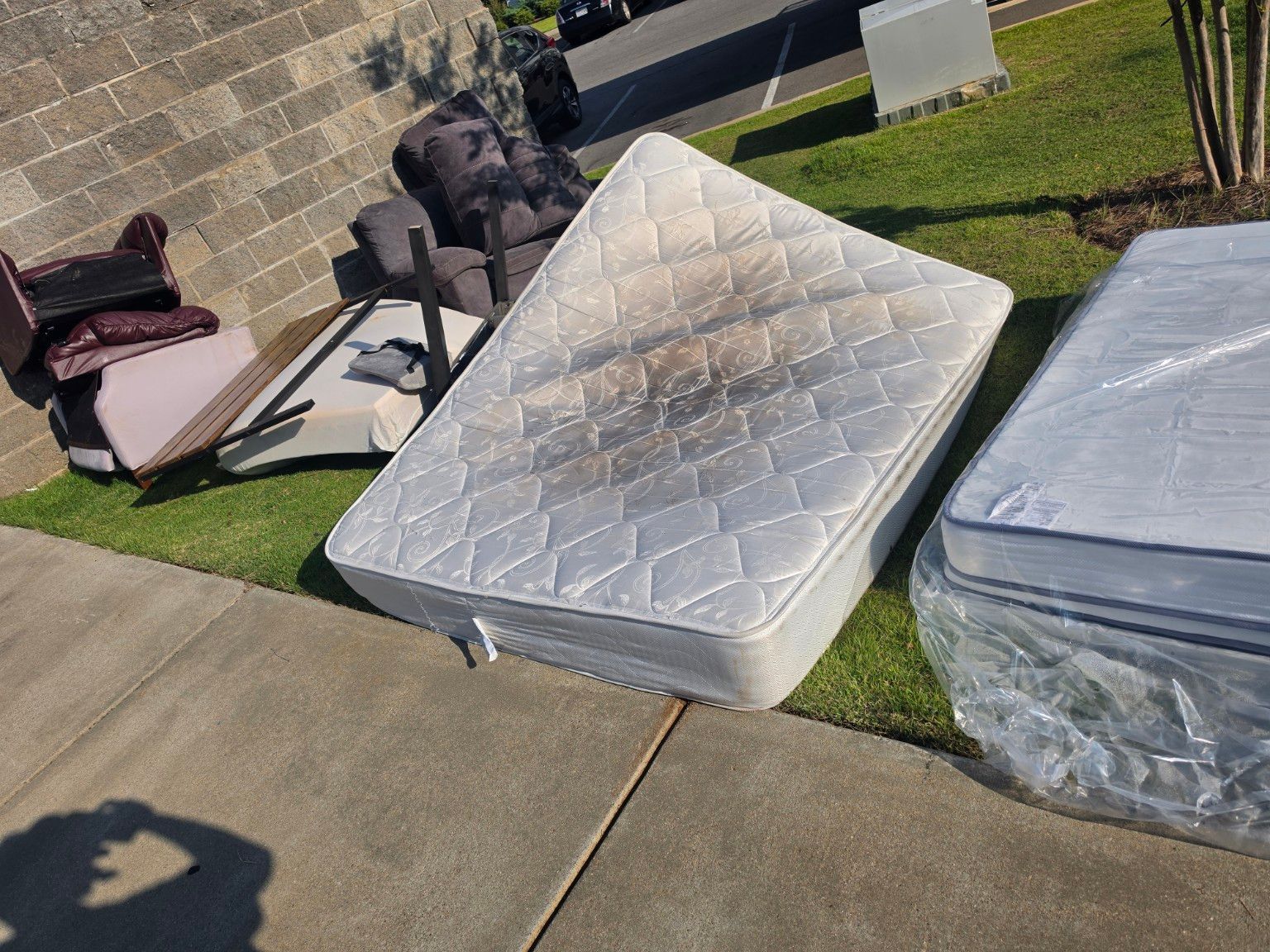 Bulk junk and mattresses before removal at an apartment community