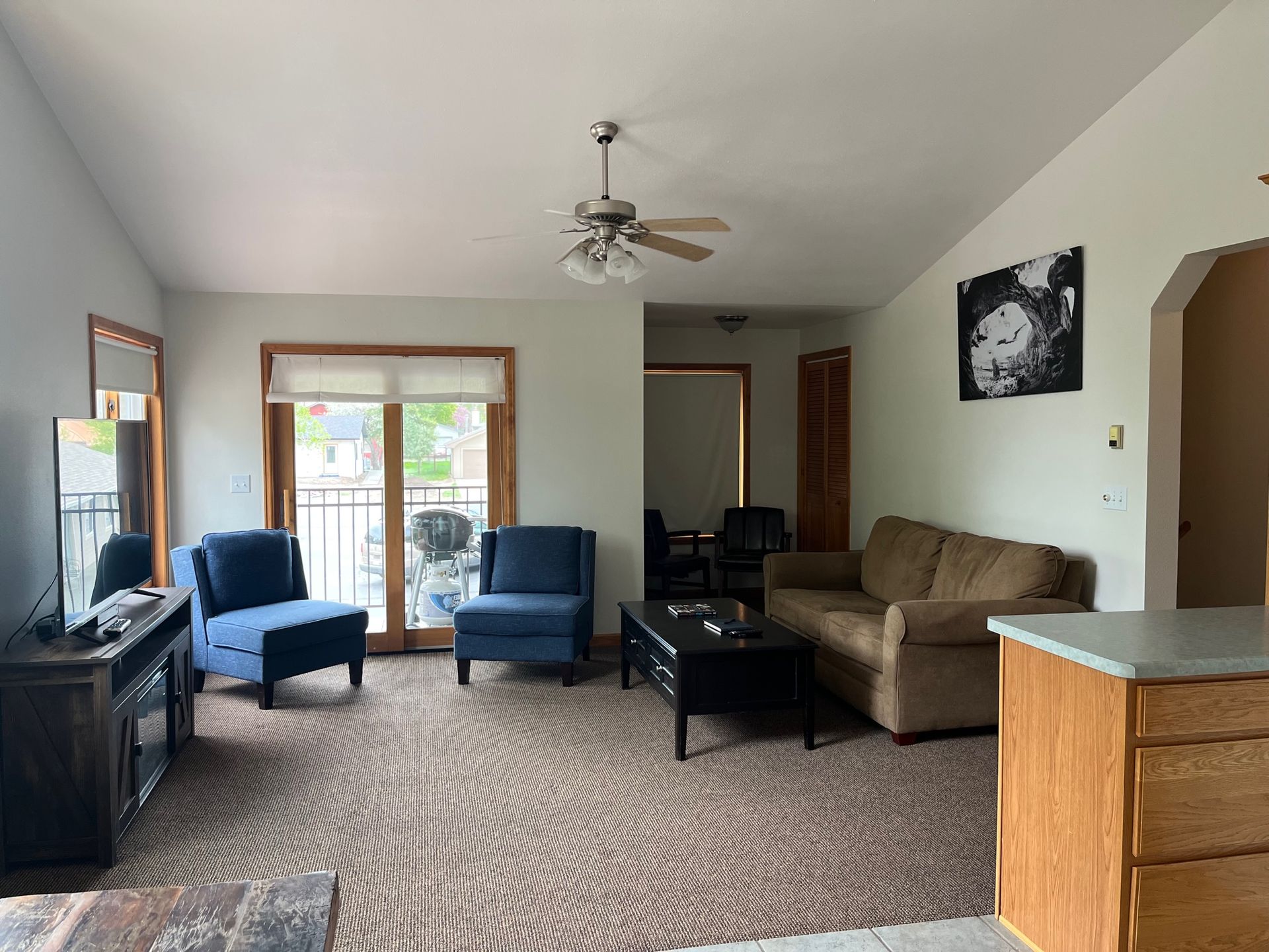 Living room with blue armchairs, a brown sofa, and a dark coffee table.