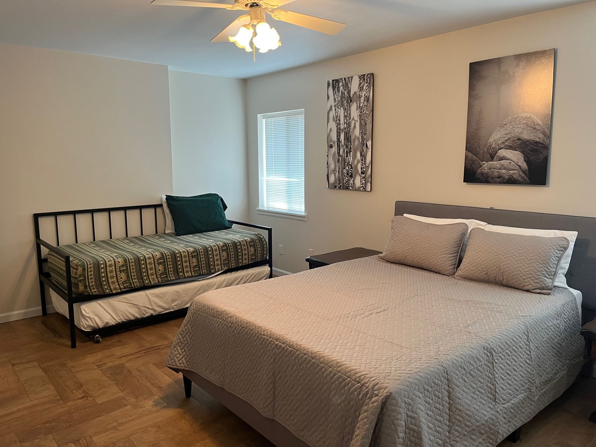 Bedroom with a double bed, daybed, and decorative wall art.