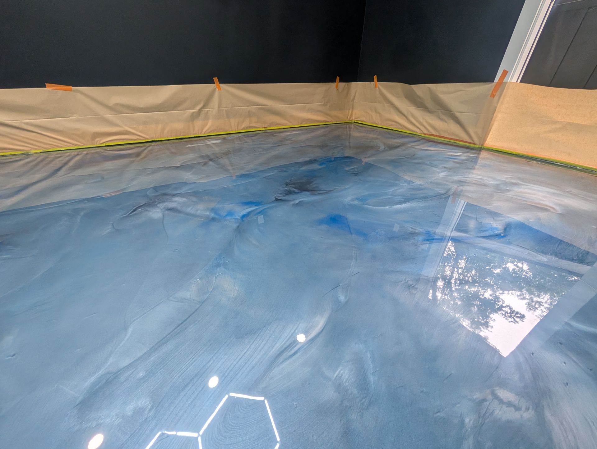 Professional installer applying metallic epoxy floor swirls