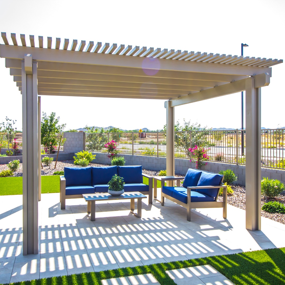 A pergola with a couch and chairs underneath it