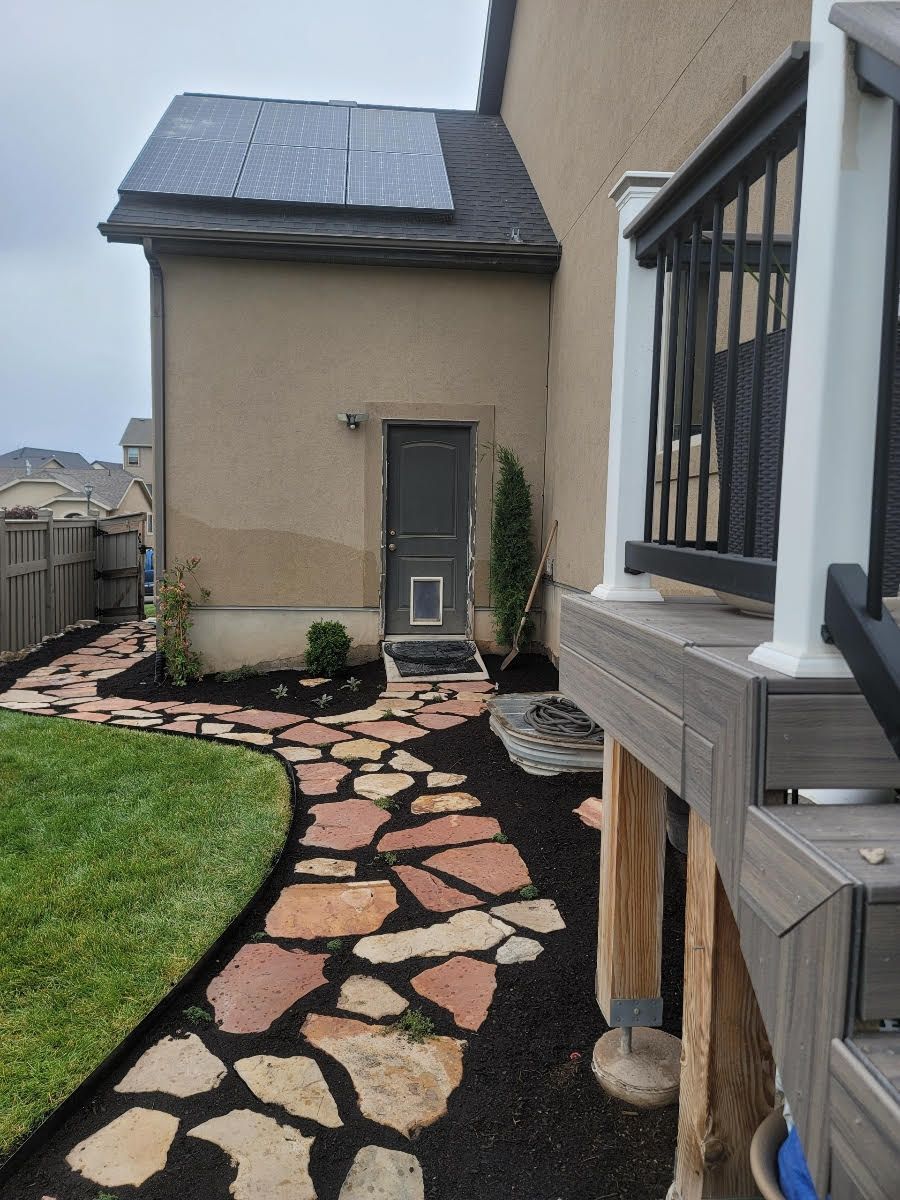 A stone walkway leading to a house with a cat door