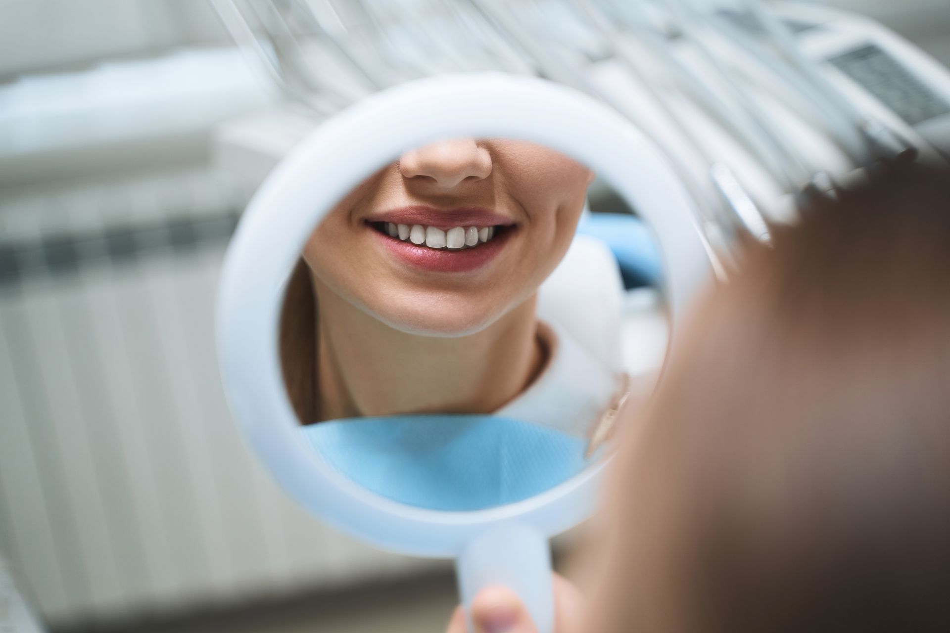 Smile reflected in a handheld mirror during a dental checkup