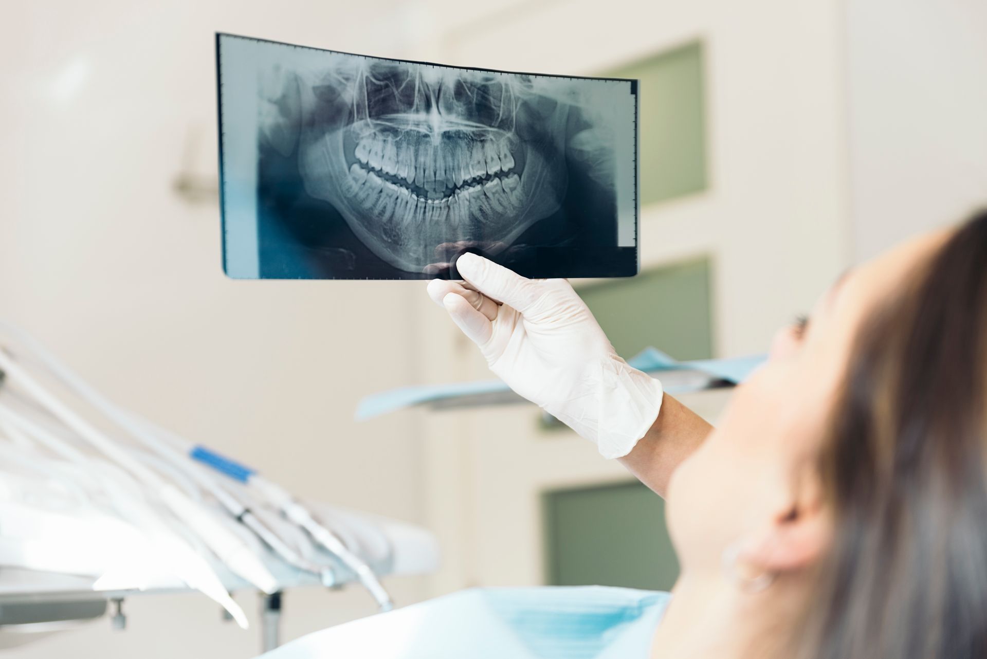 Dentist holding an X-ray of teeth during a dental exam