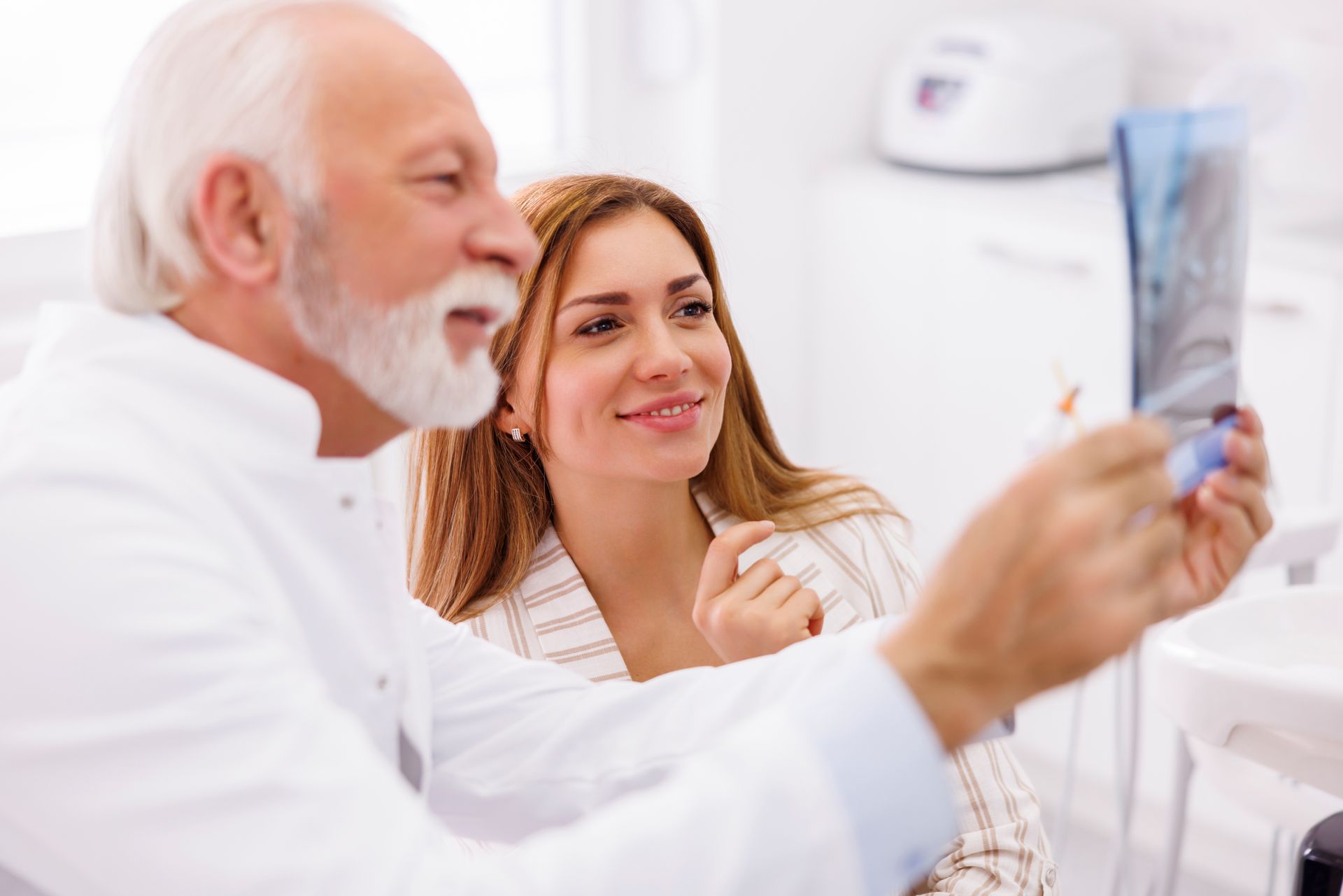 Doctor showing a dental X-ray to a smiling patient in a clinic